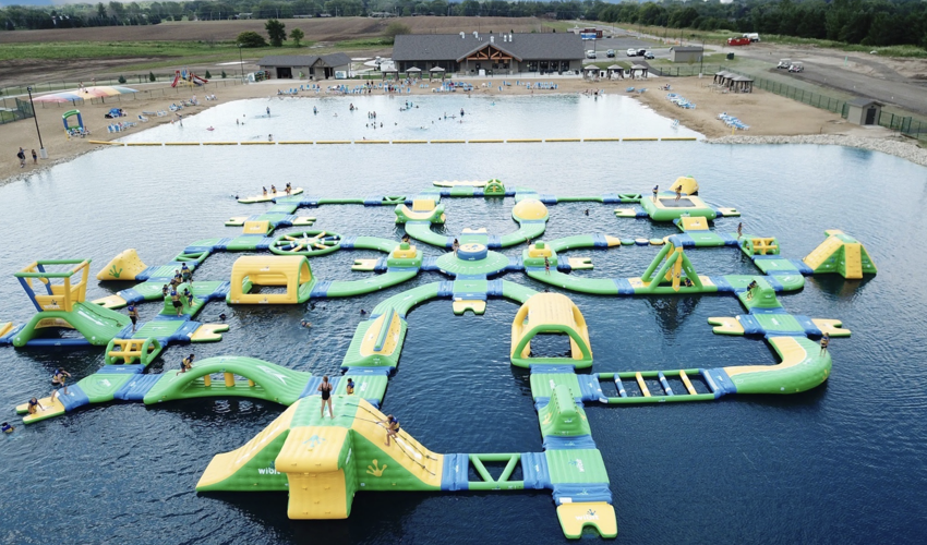 An aerial view of a large inflatable obstacle course in a lake 