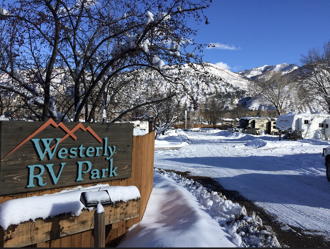 RVs in snow at a campground with a sign that reads “Westerly RV Park”