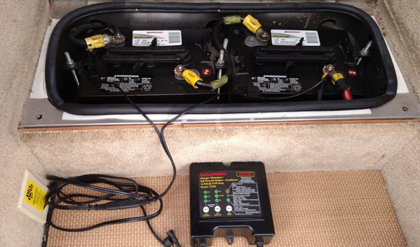 Two RV batteries are connected to a charger